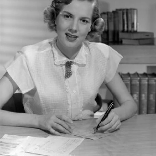 Portrait of woman sitting in office Poster Print (24 x 36)
