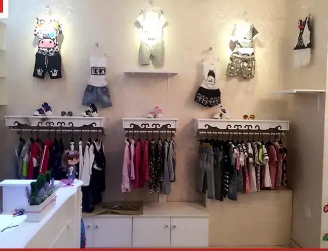 High-end women's clothing shelves. White wall-mounted hangers. Clothing store hangers.005