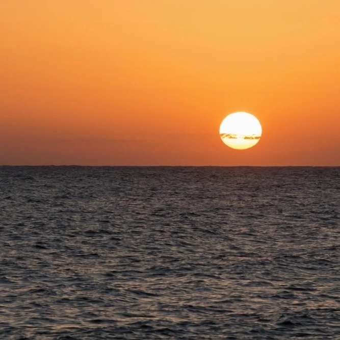 Glowing sun over the ocean and horizon at sunset; Paphos  Cyprus Poster Print (19 x 12)