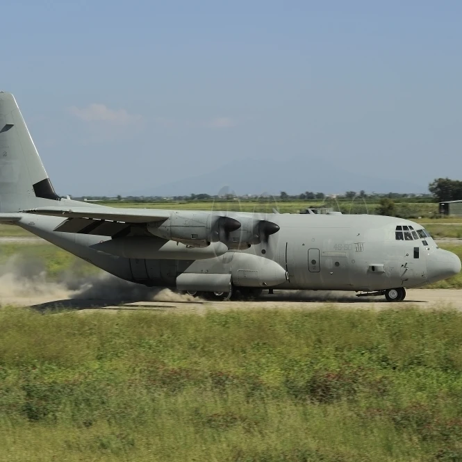 A C-130 Hercules of the Italian Air Force landing on an unpaved landing strip Poster Print (17 x 11)