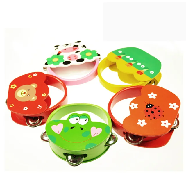 Infant hand grasping a wooden hand tambourine rattles baby child