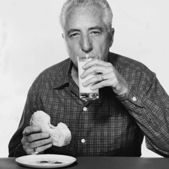 Portrait of a mature man drinking milk and eating bread Poster Print (18 x 24)