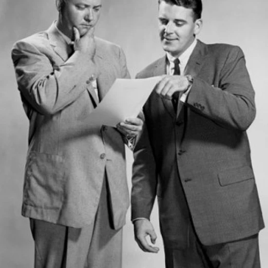Two businessmen standing discussing document Poster Print (18 x 24)
