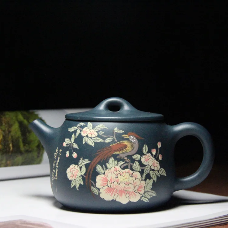 a famous Yixing purple sand teapot artist, paints large mouths of