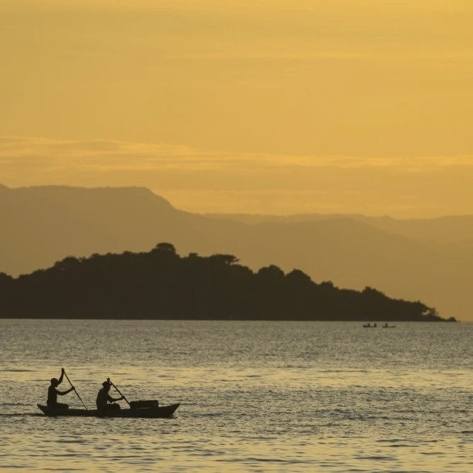 Silhouette of fishermen in dugout canoe leaving Cape Maclear in the evening  Lake Malawi; Malawi Poster Print (38 x 24)