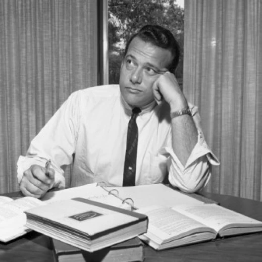 Bored businessman sitting in the office and looking away Poster Print (24 x 36)