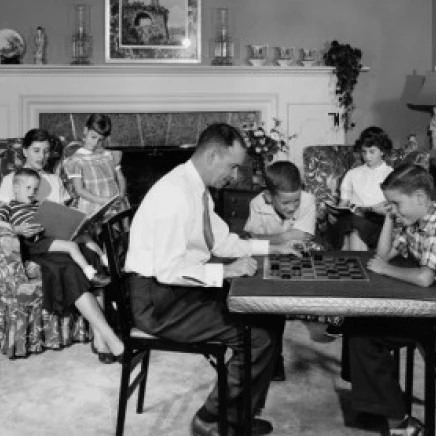 Parents and children sitting in living room Poster Print (18 x 24)