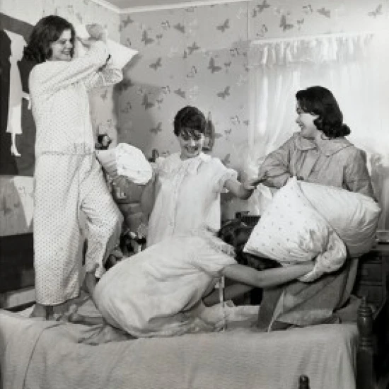 Four teenage girls having a pillow fight Poster Print (24 x 36)