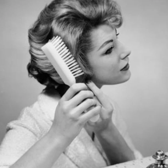 Close-up of a young woman brushing her hair Poster Print (24 x 36)