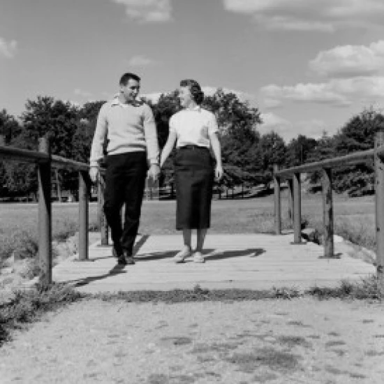 Young happy couple walking and holding hands Poster Print (18 x 24)