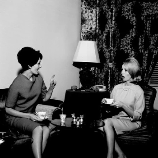 Young female friends talking over tea Poster Print (24 x 36)