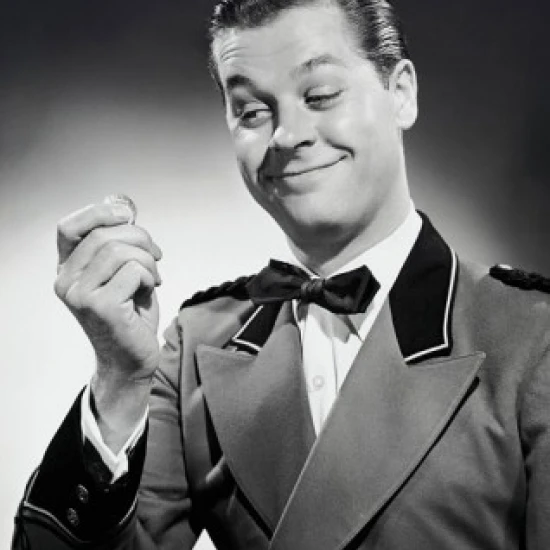 Close-up of a bellhop smiling and holding a coin Poster Print (18 x 24)