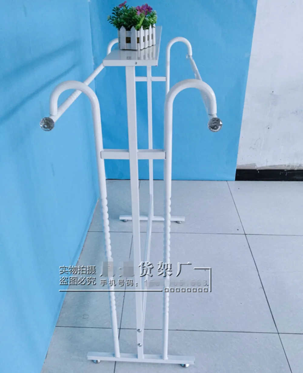 Clothing store display shelf. Console, wrought iron clothes frame. The parallel bars hangers.