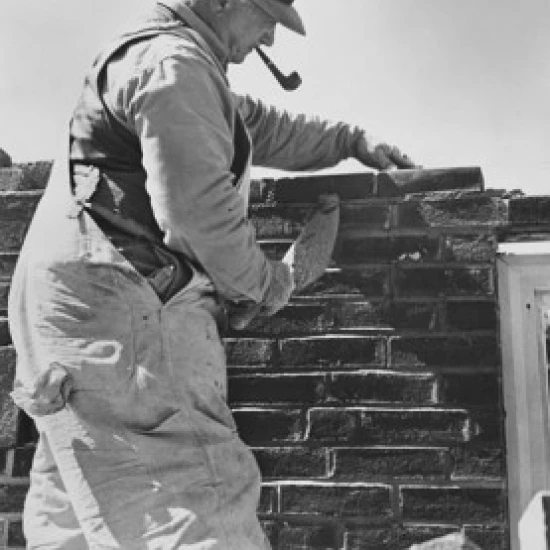Side profile of a senior man laying bricks Poster Print (18 x 24)