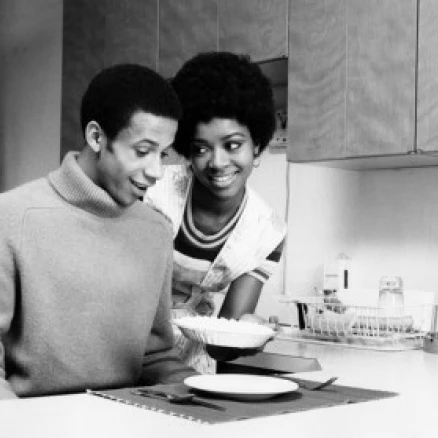 Young woman serving food to a young man Poster Print (18 x 24)