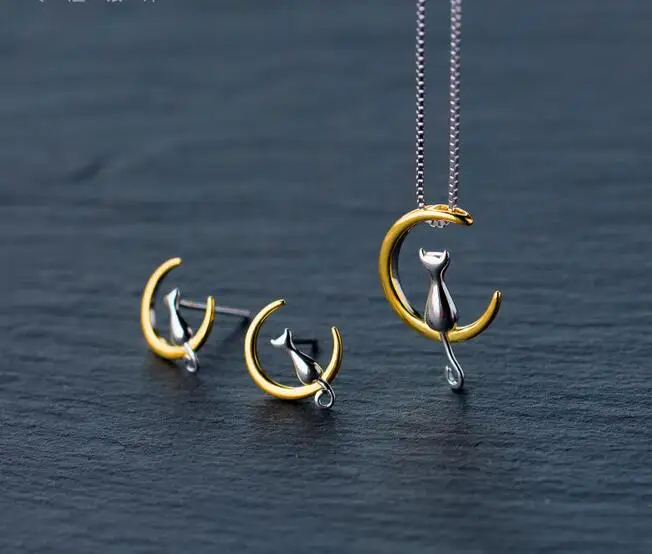 Реальные. Серебряное ожерелье и лунное котенка кошки сидя у золотого полумесяца