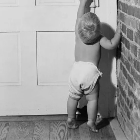 Rear view of a baby opening a door Poster Print (18 x 24)