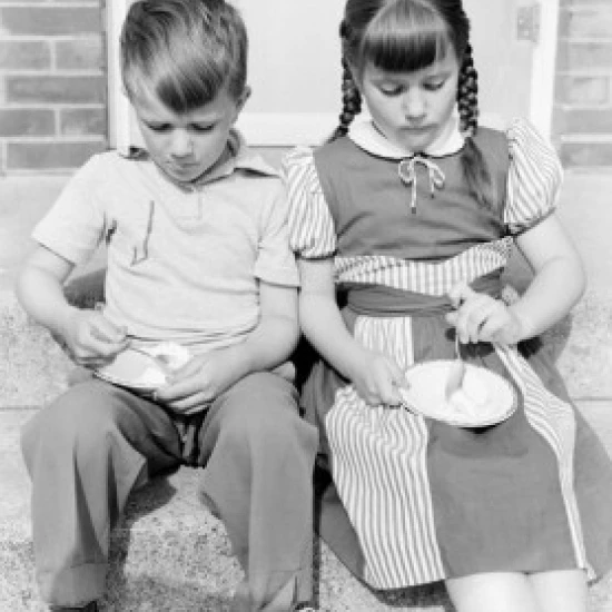 Boy and girl eating ice cream on porch Poster Print (18 x 24)