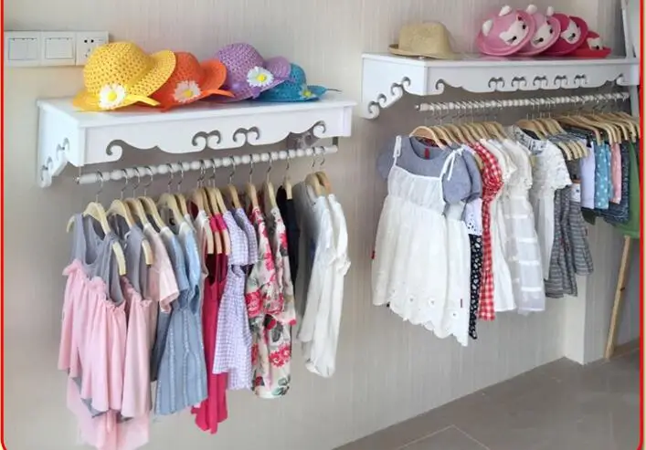 

High-end women's clothing shelves. White wall-mounted hangers. Clothing store hangers.005