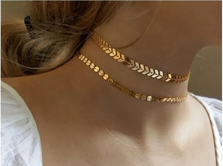 Model wearing layered choker necklace in elegant fashion style.