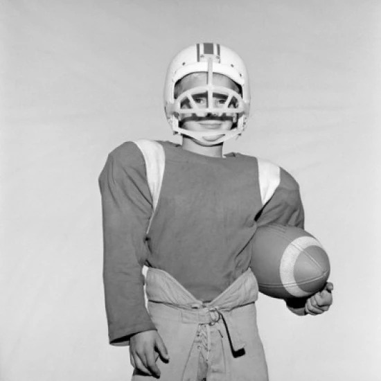 Boy wearing football helmet and holding football Poster Print (18 x 24)