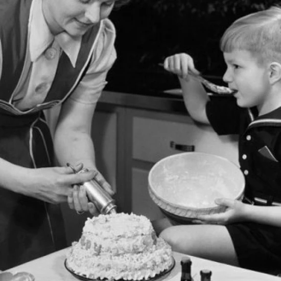 Mid adult woman preparing a cake with her son sitting beside her Poster Print (18 x 24)