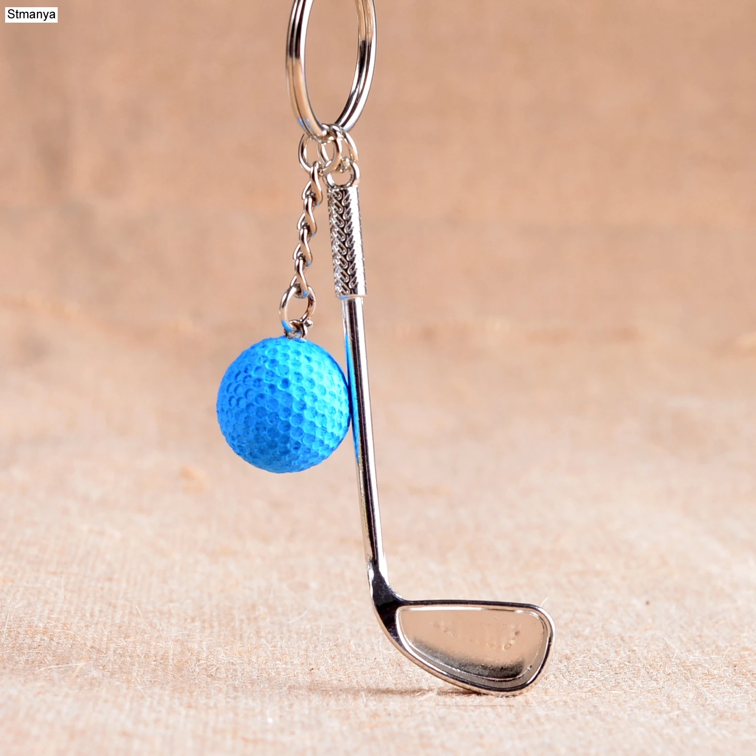 Porte-clé en métal argenté avec une balle et un club de golf