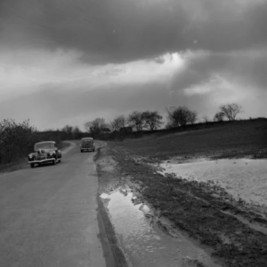 Cars passing each other under cloudy skies Poster Print (24 x 36)