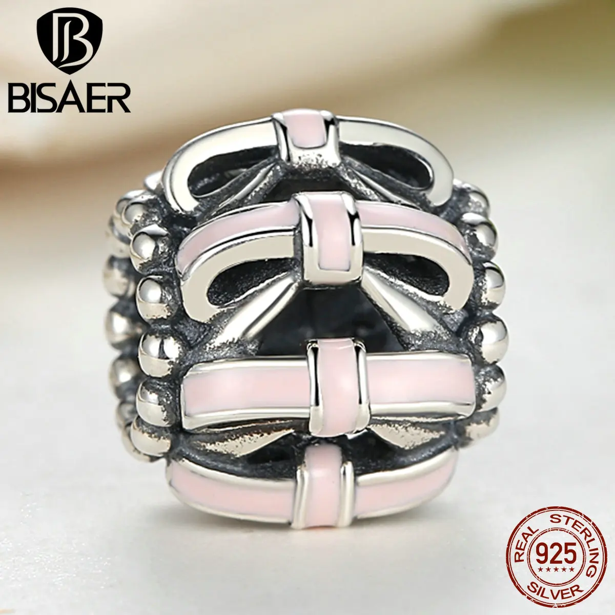 openwork bow silver charm with soft pink enamel openwork bow silver charm with soft pink enamel