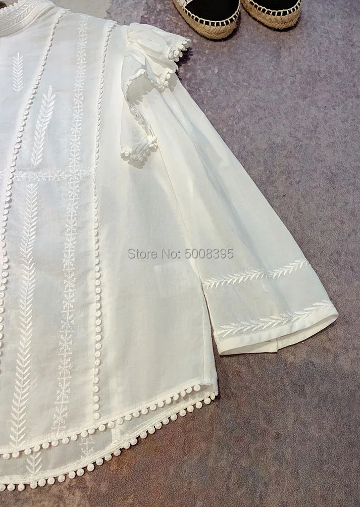 Белая серая вышитая блузка с высоким воротом на плече с оборками 3/4 рукавами