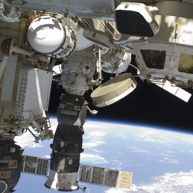 The Cupola of the International Space Station and a docked Russian Progress spacecraft Poster Print (34 x 22)