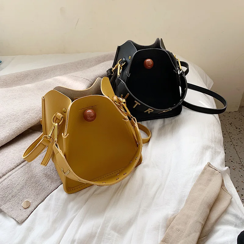 

Trapezoidal Water Barrel Bag Metal Letter Shoulder Belt Buddhist Fastener Button Single Shoulder Oblique Woman Bag Wholesale