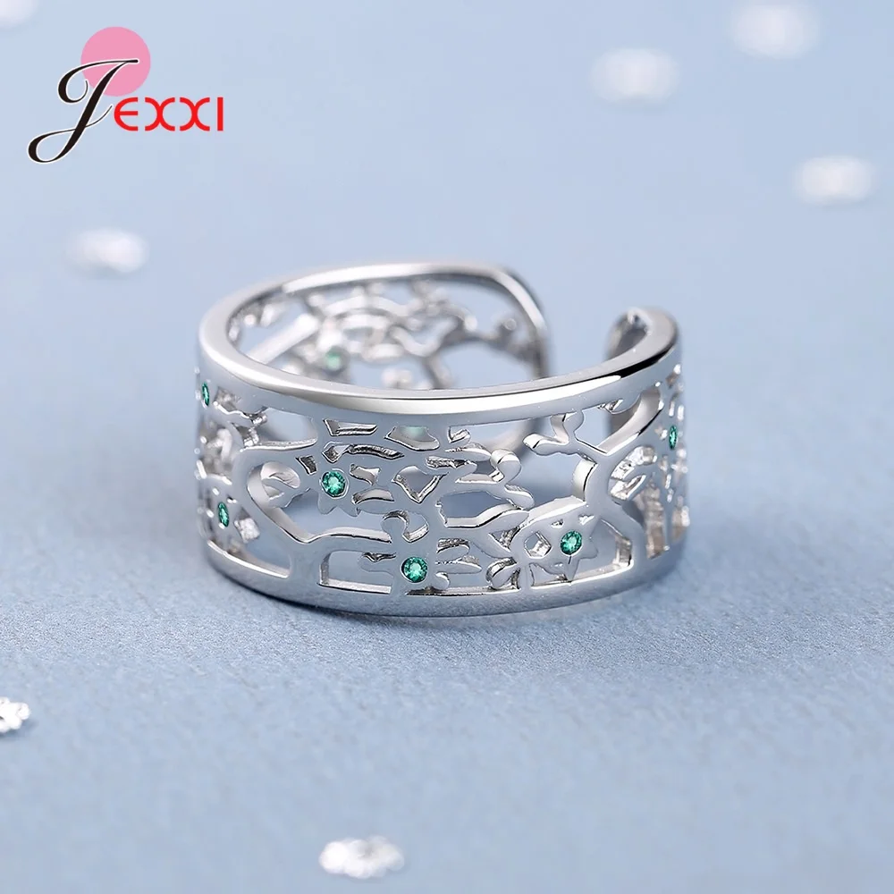 Anneau ouvert arbre de vie en argent sterling, avec un motif floral évidé complexe et des pierres de zircon vert intégrées.