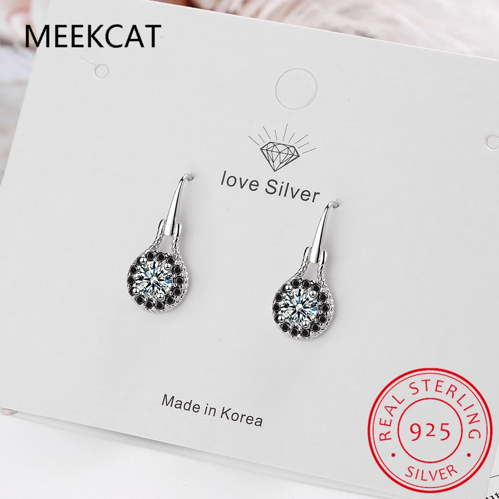 Boucles d’oreilles pendantes en spinelle noir avec argent sterling comprenant un cristal central transparent entouré de cristaux noirs, avec une fermeture à crochet élégante.