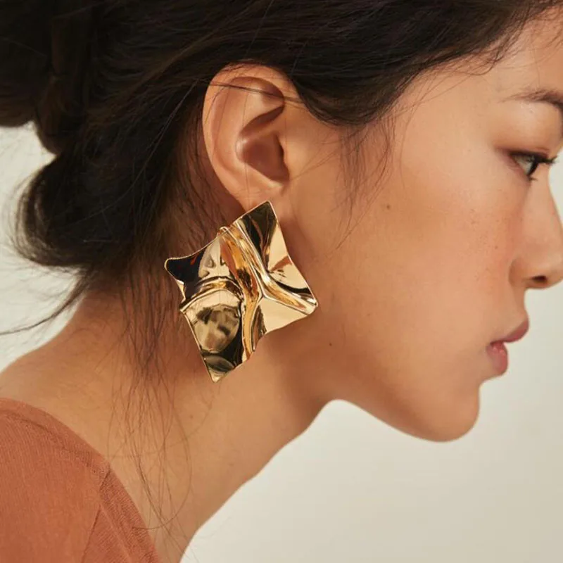 A woman wearing a pair of Top Fashion Twisted Metal Earrings.