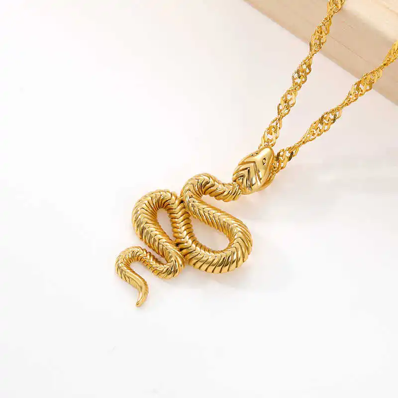 A stylish jewelry piece, the Snake Pendant necklace features a captivating snake-shaped pendant beautifully showcased on a pristine white surface, making it an essential addition to women's fashion accessories.