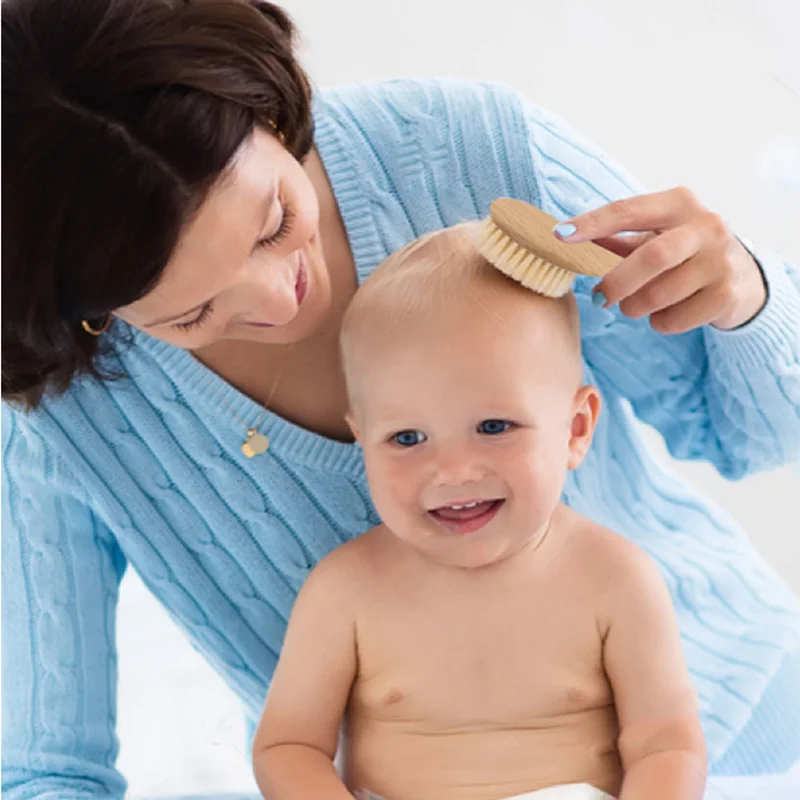 Mamá peine a un bebé recién nacido con un cepillo especial para el cabello.  Higiene del bebé Fotografía de stock - Alamy