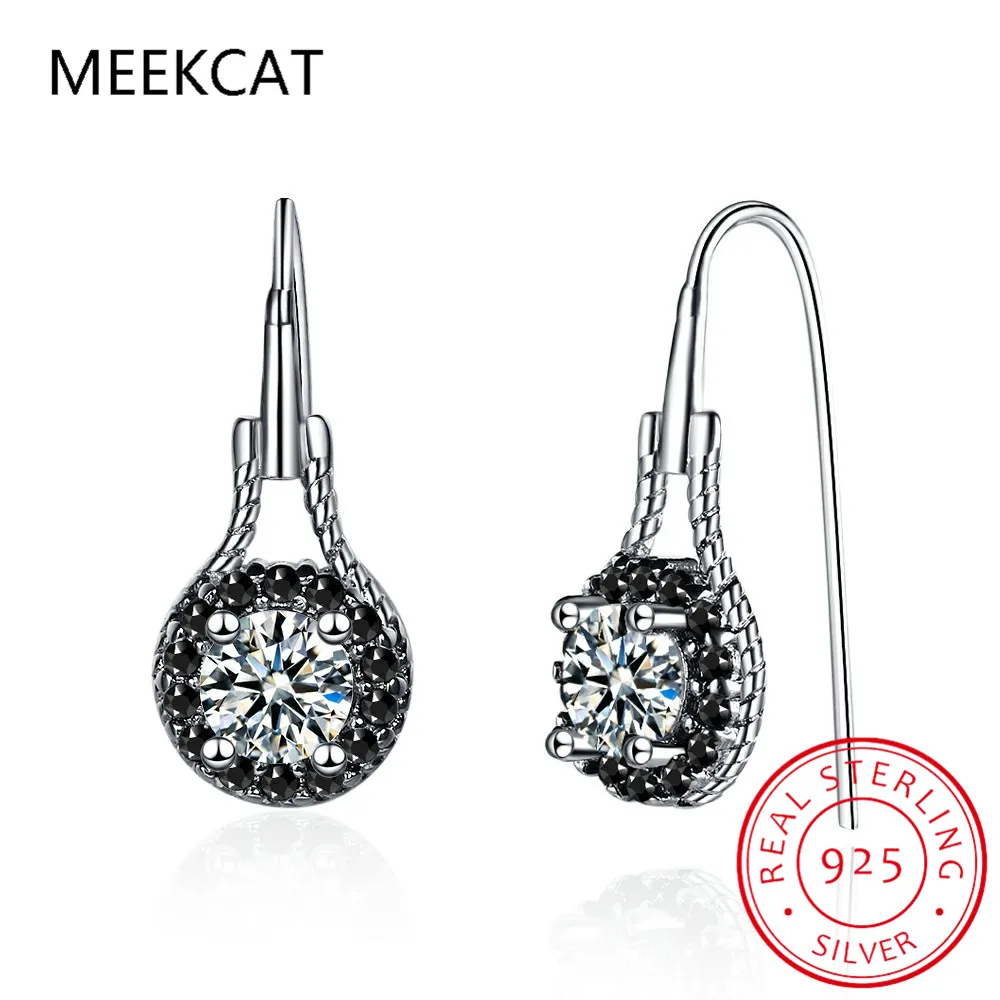 Boucles d’oreilles pendantes en spinelle noir avec argent sterling comprenant une pierre centrale transparente entourée de pierres d’accent noires et d’un dessin délicat en fil torsadé.