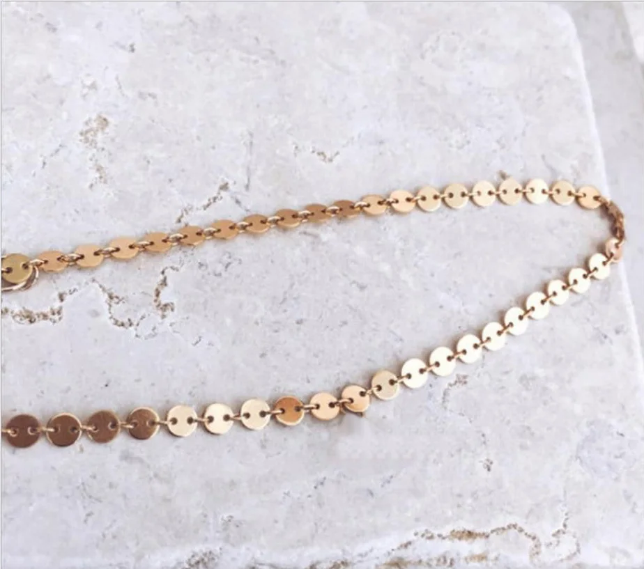 Model wearing layered choker necklace in elegant fashion style.