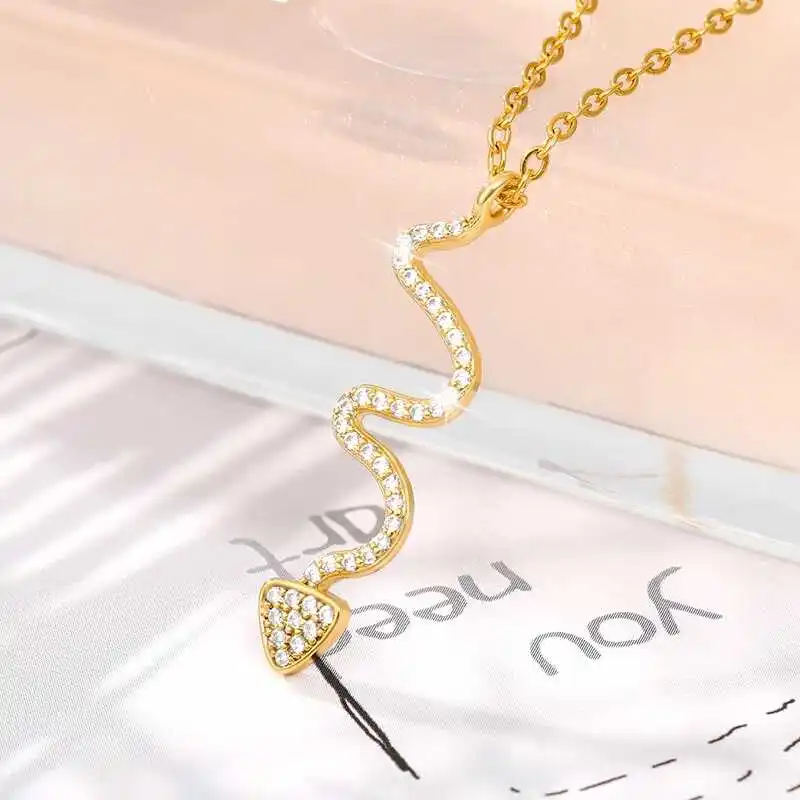 Snake Pendant necklace featuring a gold-toned, wavy pendant adorned with diamonds, elegantly displayed on a light-colored background. Ideal for those who have an eye for stylish jewelry and fashion accessories.