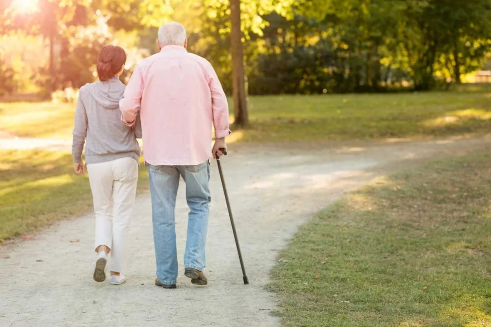 senior-with-cane-walking-with-young-woman