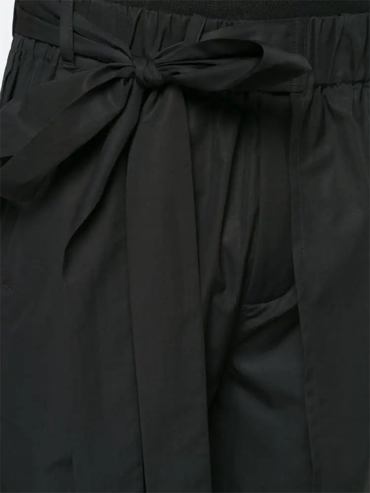 The new men\'s cropped trousers are dark and large size loose trousers with irregular asymmetrical wide legs