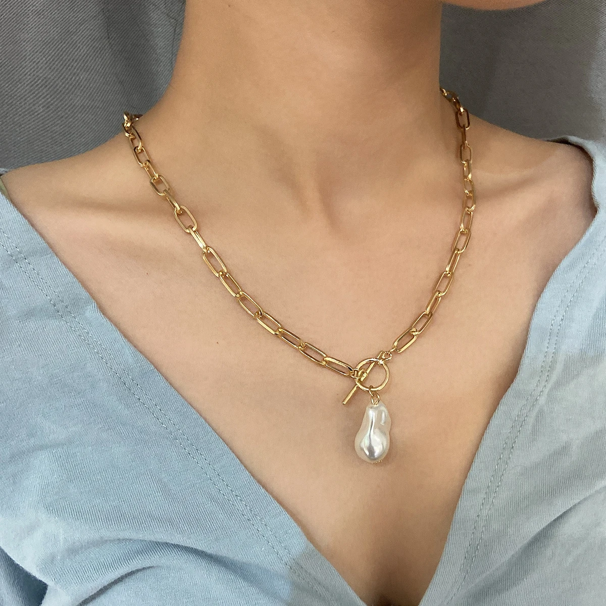 A woman wearing a Women's Baroque Pearl Coin Pendant Necklace.