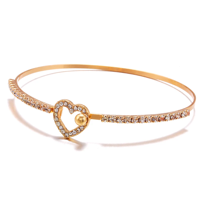Женский браслет на запястье золотого цвета с открытым сердцем и кристаллами