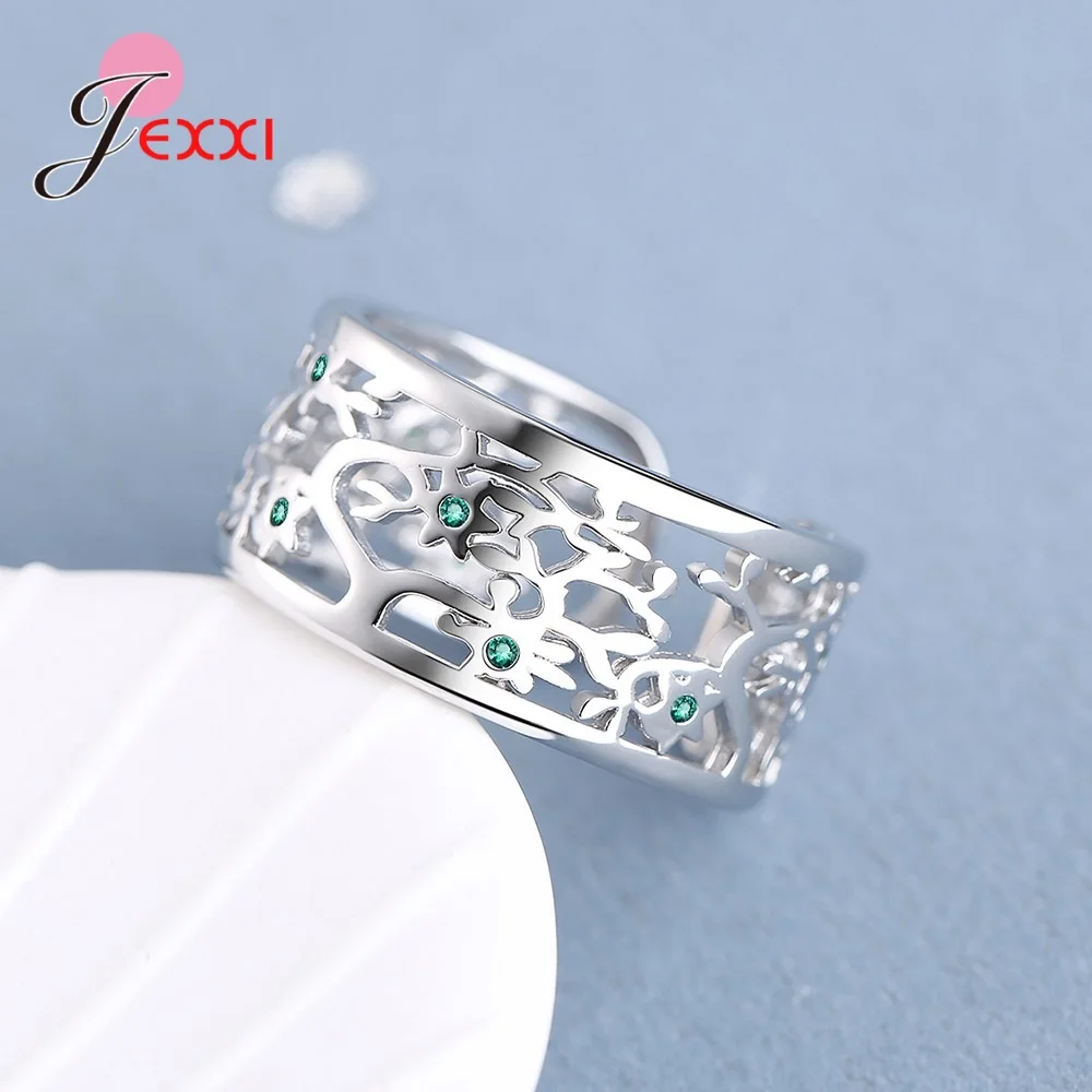 Anneau ouvert arbre de vie en argent sterling avec un design ajouré complexe et des pierres de zircon vert intégrées.