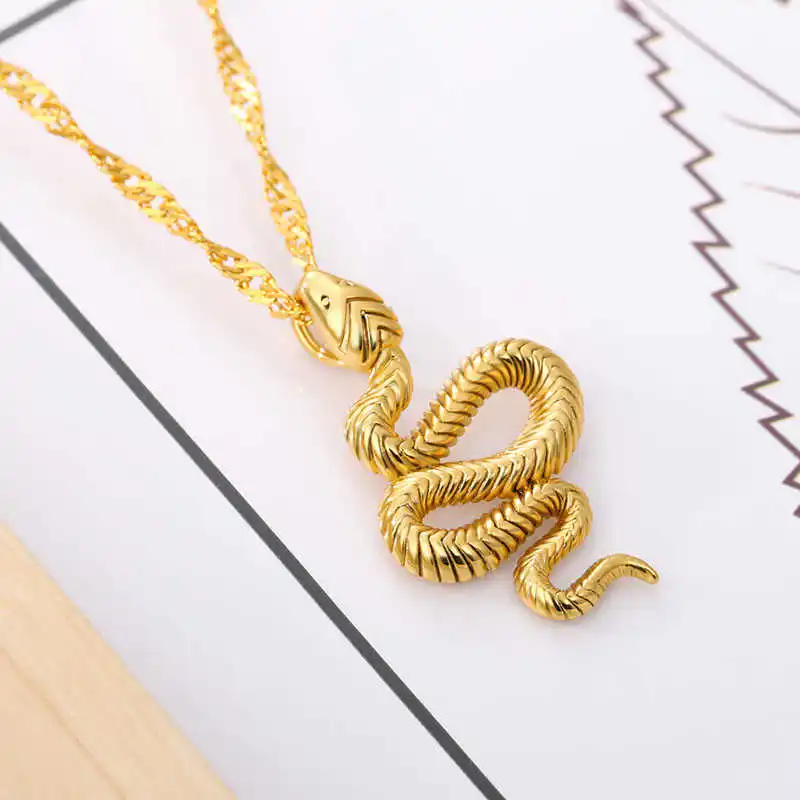 A Snake Pendant, a stylish piece of women's fashion accessories, is placed on a piece of paper with black and zigzag lines.