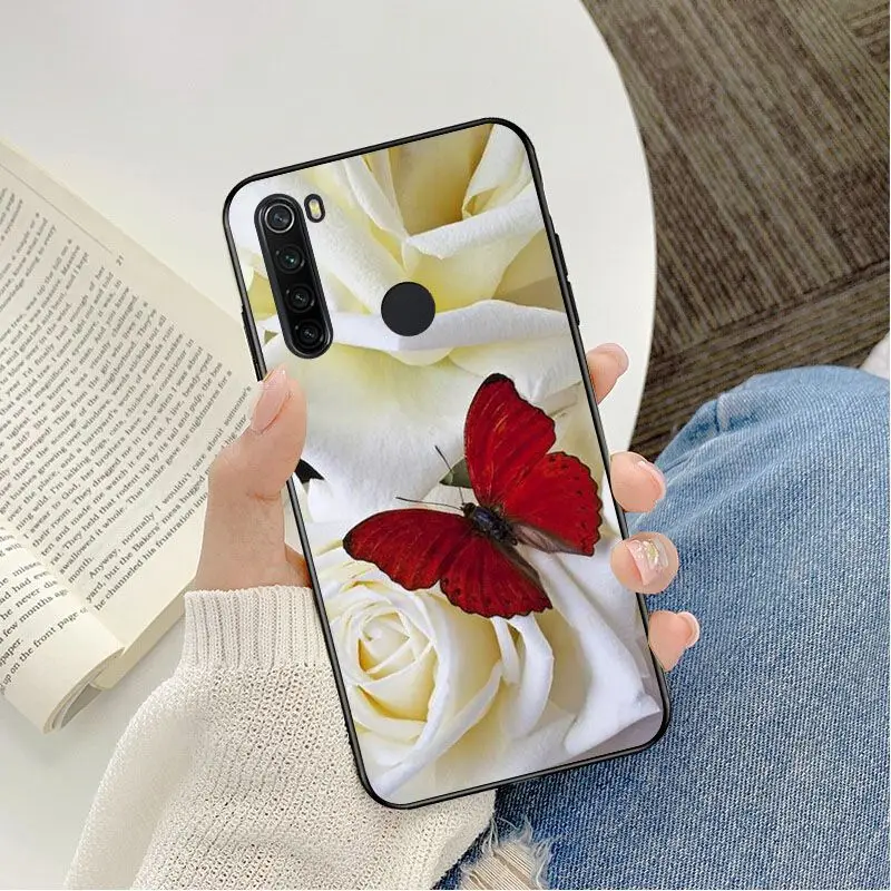 Red butterfly on white roses flower