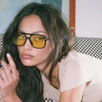 A woman in Vintage Square Sunglasses posing on a couch.