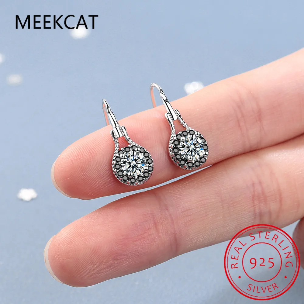 Boucles d’oreilles pendantes en spinelle noir avec argent sterling comprenant des cristaux centraux transparents entourés de pierres d’accent foncées plus petites, dans une conception circulaire complexe.