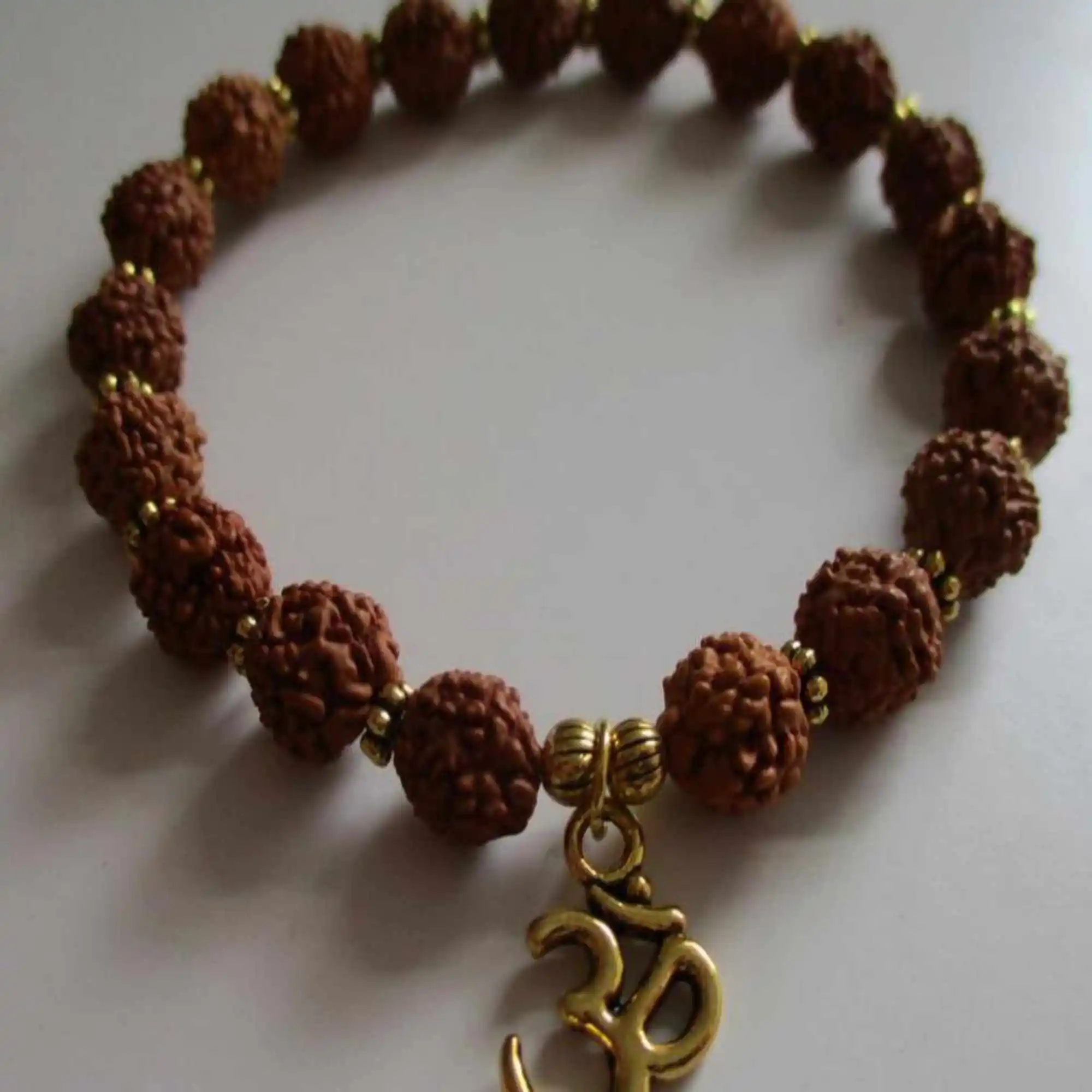 Naturalna bransoletka Rudraksha z koralikami na nadgarstek Mala Gold Charm, która nadaje się do układania w stosy, rzemieślniczy, czeski, formalny miłośnik biżuteria Unisex